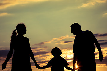 Image showing Happy family standing in the park at the sunset time.