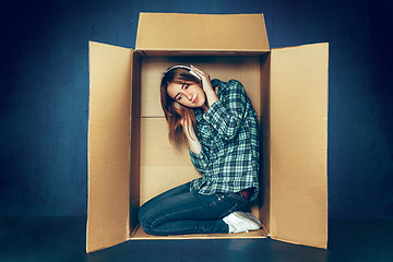 Image showing Introvert concept. Woman sitting inside box and working with laptop