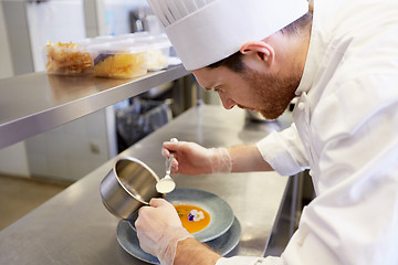 Image showing happy male chef cooking food at restaurant kitchen