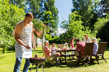 Image showing man cooking meat on barbecue grill at summer party