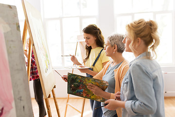 Image showing women with easel and palettes at art school