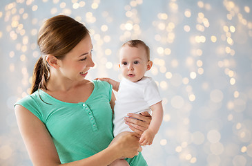 Image showing happy young mother with baby over holidays lights