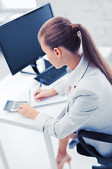 Image showing businesswoman with notebook and calculator