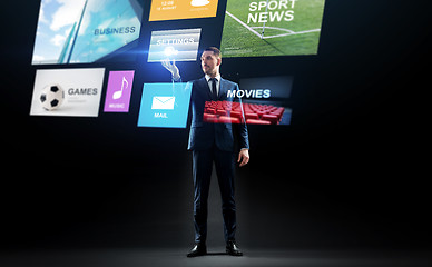 Image showing businessman with applications on virtual screen