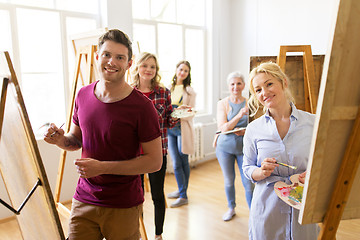 Image showing artists with brushes painting at art school