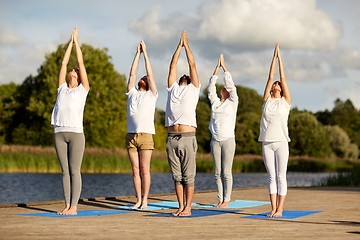 Image showing group of people making yoga exercises outdoors