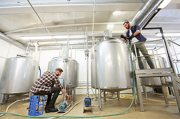 Image showing men working at craft beer brewery kettles