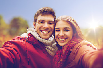 Image showing happy young couple taking selfie in autumn park