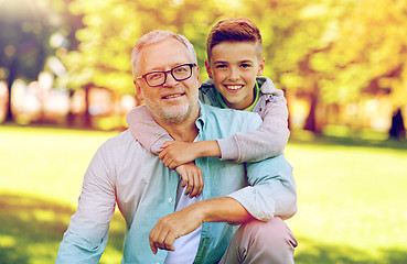 Image showing grandfather and grandson hugging at summer park