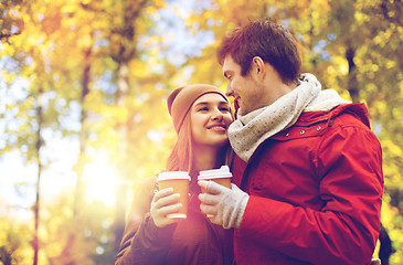 Image showing happy couple with coffee walking in autumn park