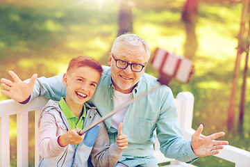 Image showing old man and boy taking selfie by smartphone