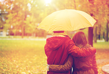 Image showing happy couple with umbrella walking in autumn park