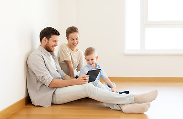 Image showing happy family with tablet pc moving to new home