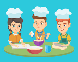 Image showing Caucasian boys and girl in chef hats cook cookies.