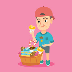 Image showing Boy holding a cupcake and stroking his belly.