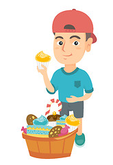 Image showing Boy holding a cupcake and stroking his belly.