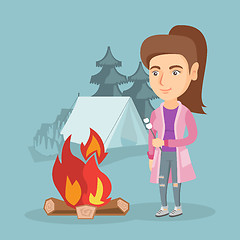 Image showing Caucasian woman roasting marshmallow over campfire