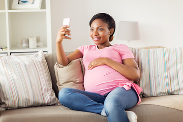 Image showing pregnant woman taking smartphone selfie at home