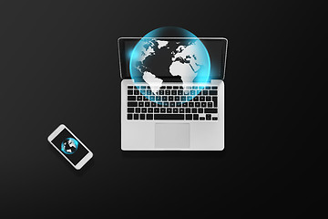 Image showing laptop with earth projection and smartphone