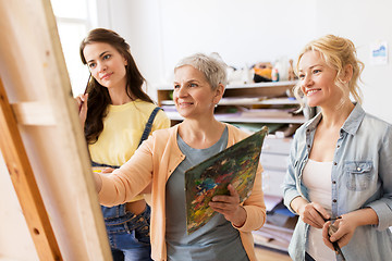 Image showing women with easel and palettes at art school