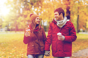 Image showing happy couple with coffee walking in autumn park