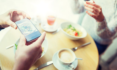 Image showing close up of couple picturing food by smartphone