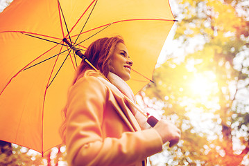 Image showing happy woman with umbrella walking in autumn park