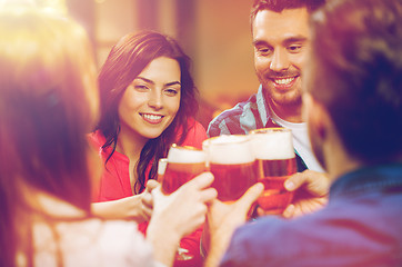 Image showing friends drinking beer and clinking glasses at pub