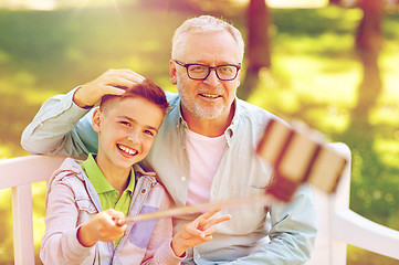 Image showing old man and boy taking selfie by smartphone