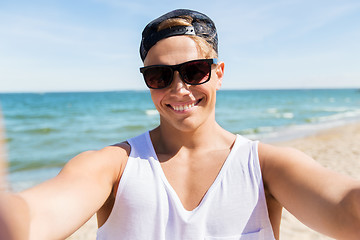 Image showing man in sunglasses taking selfie on summer beach