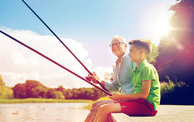 Image showing grandfather and grandson fishing on river berth