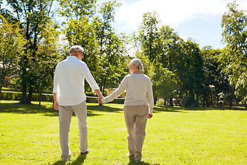 Image showing happy senior couple walking at summer city park
