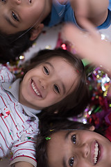 Image showing kids  blowing confetti while lying on the floor