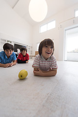 Image showing boys having fun with an apple on the floor