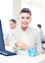 Image showing businesswoman pointing at clock in office