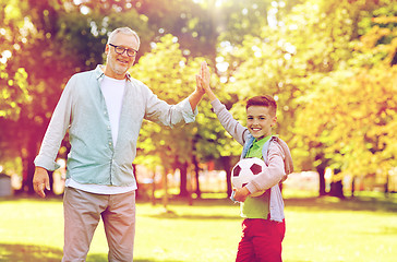 Image showing old man and boy with soccer ball making high five