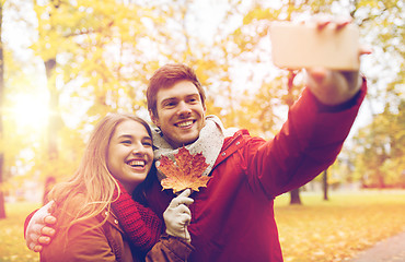 Image showing couple taking selfie by smartphone in autumn park