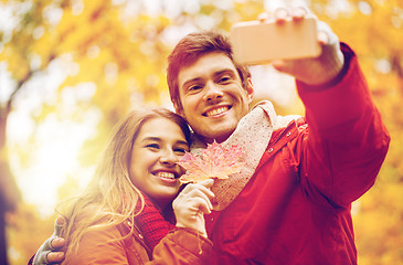 Image showing couple taking selfie by smartphone in autumn park