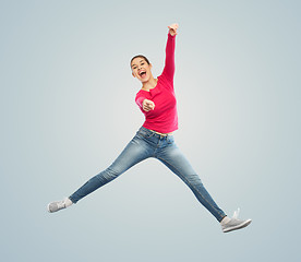 Image showing smiling young woman jumping in air