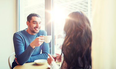 Image showing happy couple drinking tea and coffee at cafe