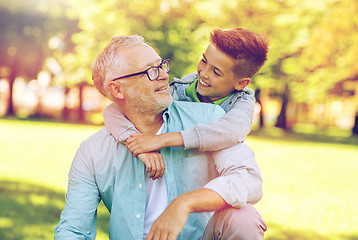 Image showing grandfather and grandson hugging at summer park