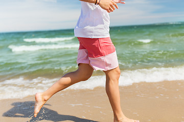 Image showing happy man running along summer beach