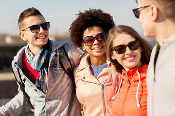 Image showing happy teenage friends in shades talking on street