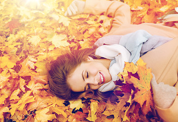 Image showing beautiful happy woman lying on autumn leaves