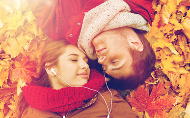 Image showing close up of smiling couple lying in autumn park