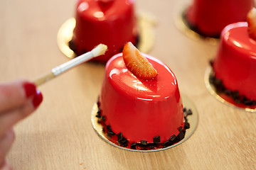 Image showing chef decorating glaze cakes at pastry shop