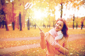 Image showing woman taking selfie by smartphone in autumn park