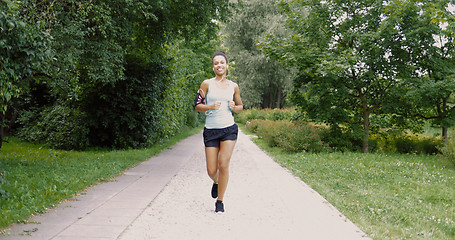 Image showing Cheerful woman running in park