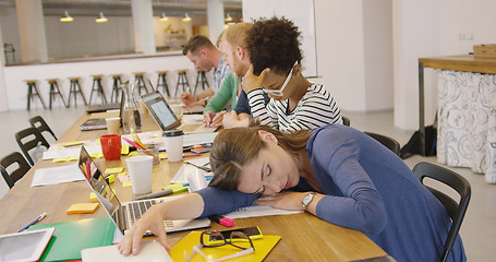 Image showing Tired worker at table in office