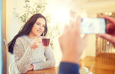 Image showing man taking picture of woman by smartphone at cafe